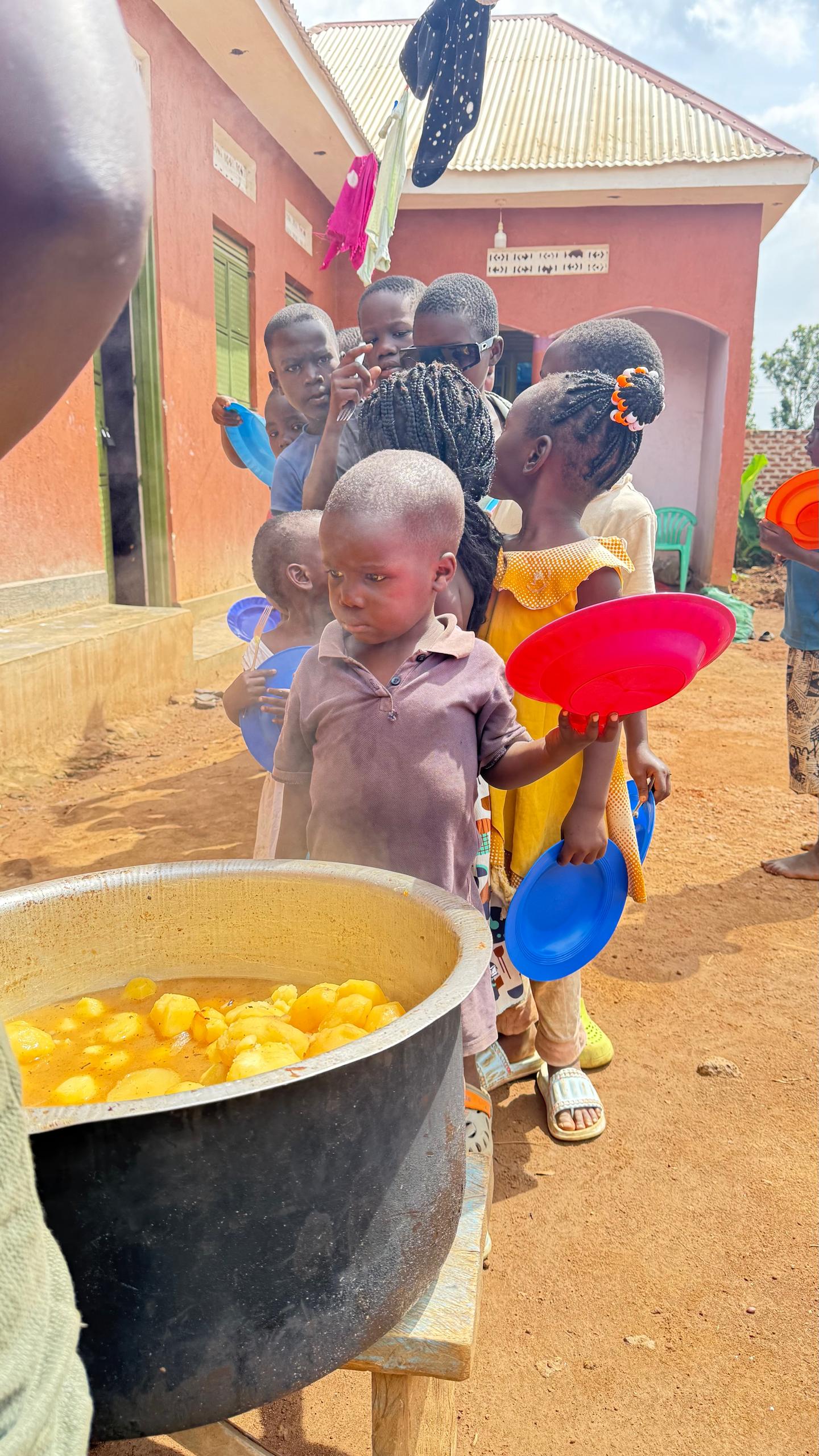 Children lining up for a meal at Above Uganda Ministries